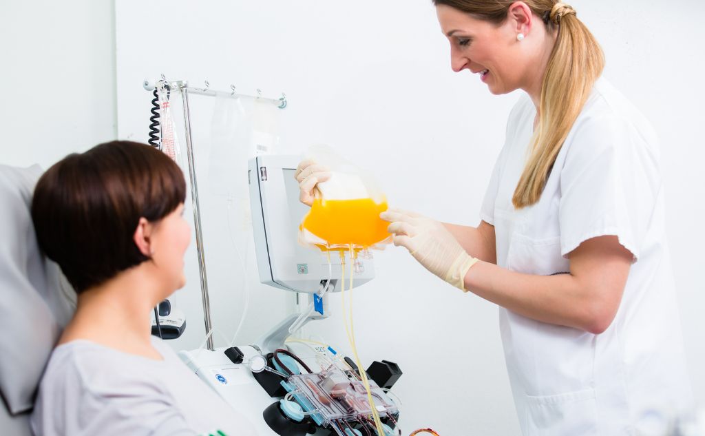 a nurse extracting plasma from a patient's body